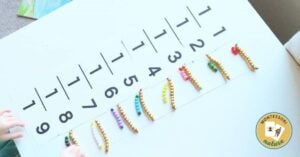 A child is playing with beads on a DIY math board.