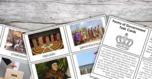 Several educational cards about types of government, such as chiefdom, republic, and gerontocracy, are spread on a wooden surface alongside a task card sheet—perfect printables for learning activities. Montessori Nature Printables