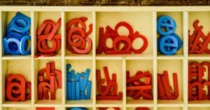 A display of wooden letters in a wooden box.