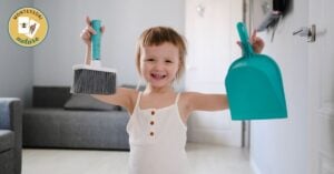 A little girl in a Montessori home is holding two brooms and a mop, ensuring an organised and clatter-free environment.